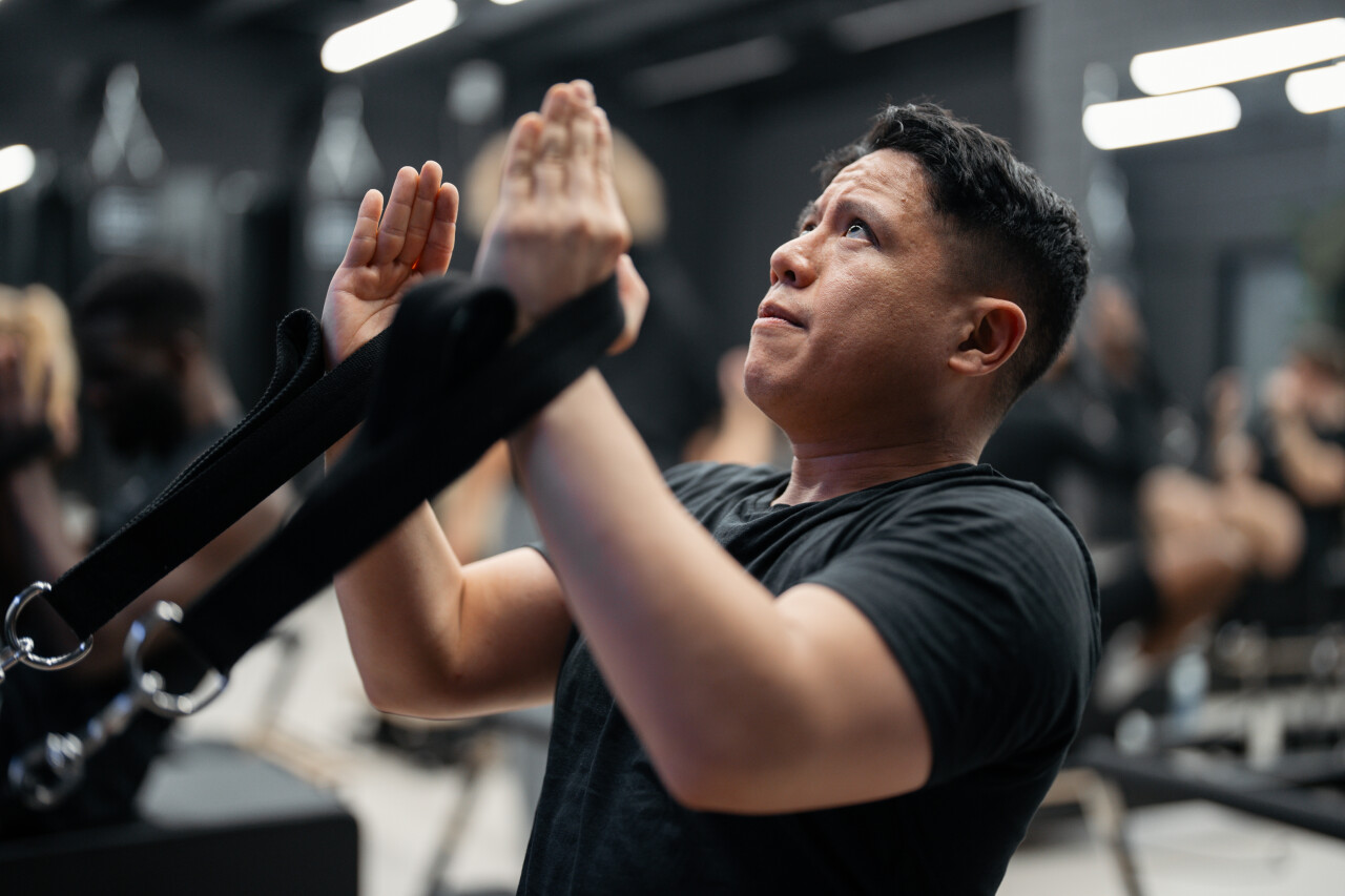 Deelnemer traint Reformer Pilates op de reformer